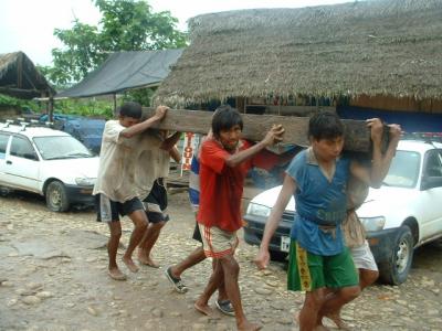 carrying logs by native people